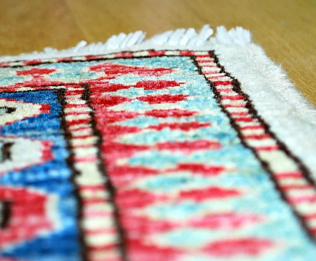 Tapis coloré en gros plan, textures préservées grâce au soin de Nettoyage Impérial.